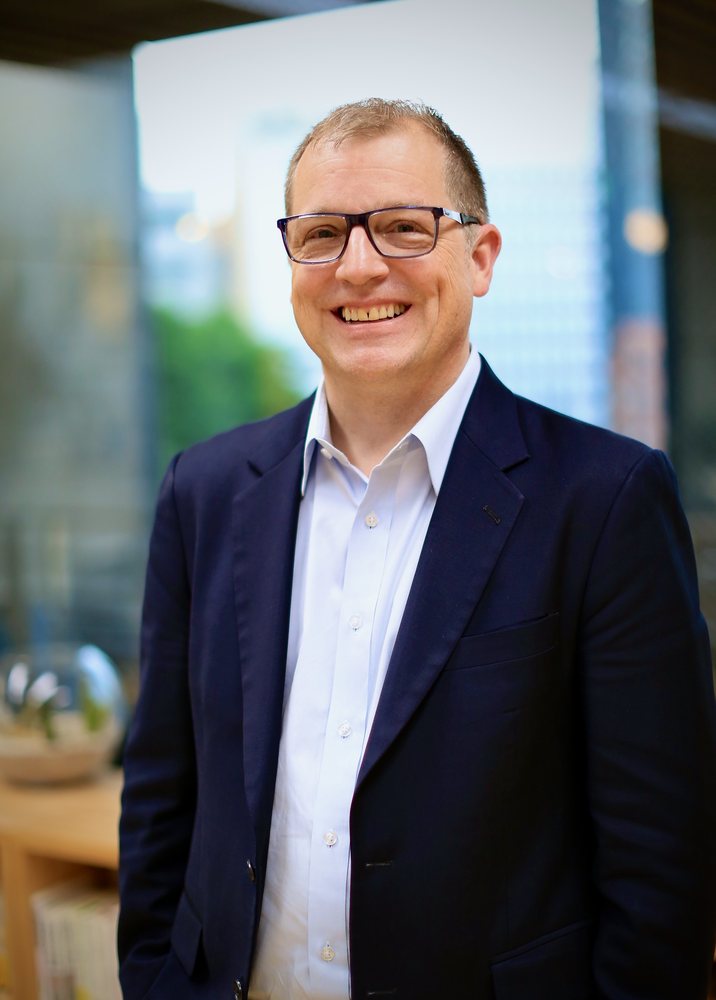 Phil LeNir, smiling, in a navy jacket
